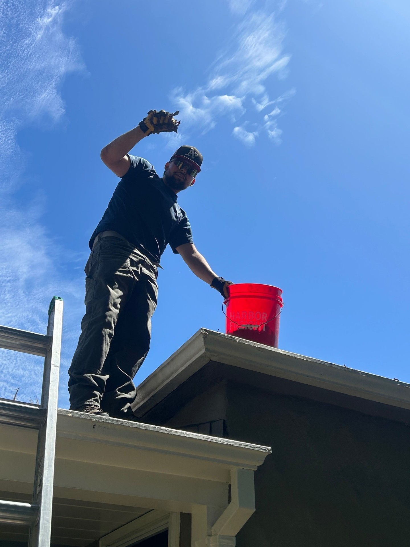 Gutter cleaning technician working at a roofline